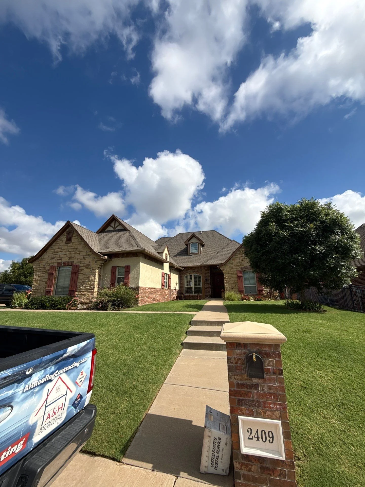 Two-story home with new asphalt shingle roof, stone and brick exterior, multiple gables