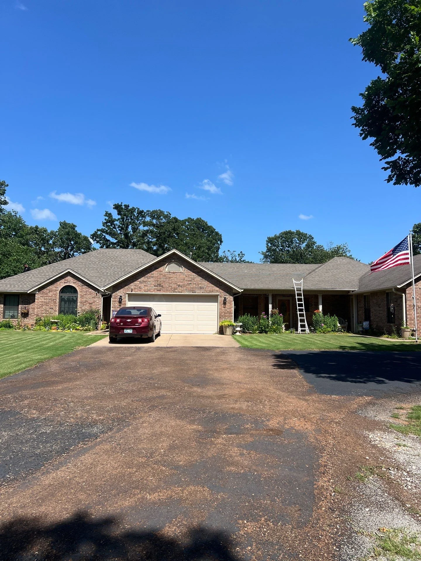Brick residential home with new gray architectural asphalt shingle roof installation