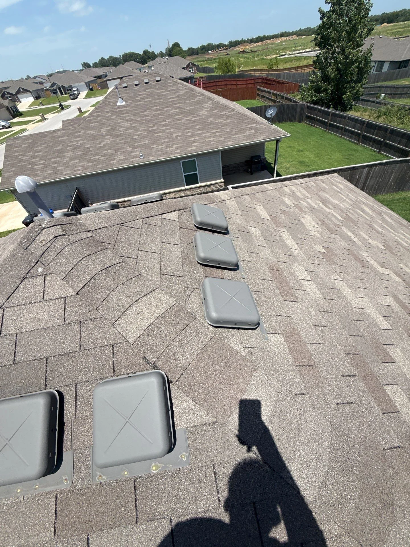 Gray architectural shingles with sealed roof vents on pitched residential roof