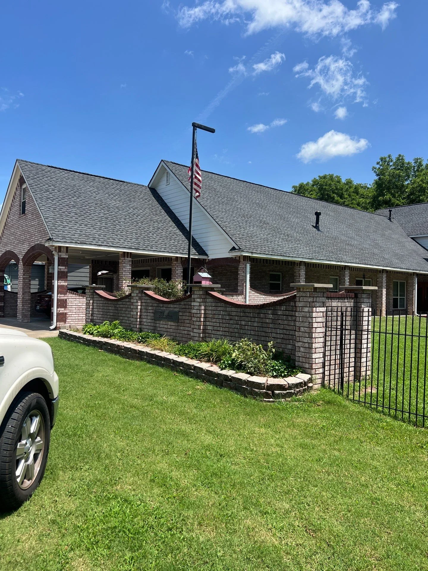 Gray architectural shingles installed on brick residential home with multiple roof planes and gable sections