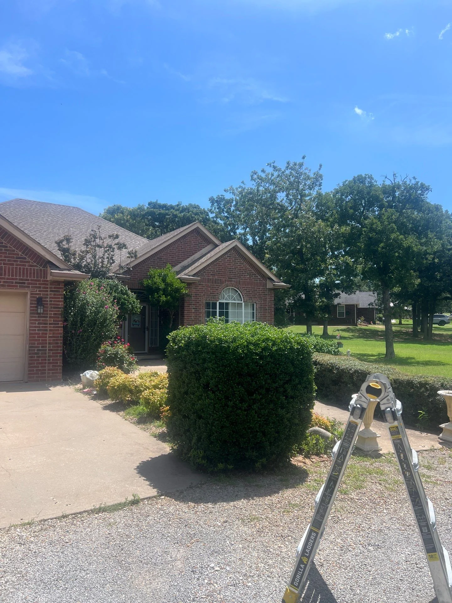 Brick home with multi-peak roof and measurement equipment for roofing assessment